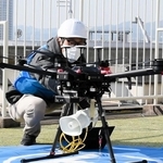 神戸国際会館の屋上でスピーカーを搭載したドローンの準備をする担当者＝神戸市中央区御幸通８
