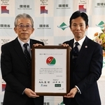 締結書を手にする好日山荘の松本良一社長（右）と、環境省の植田明浩自然環境局長＝東京・霞が関（好日山荘提供）