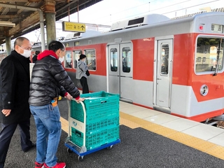 電車車両に農産物を積み込む「神鉄食彩館　新開地店」の従業員ら＝神戸市北区藤原台中町１、神戸電鉄岡場駅（神戸市提供）