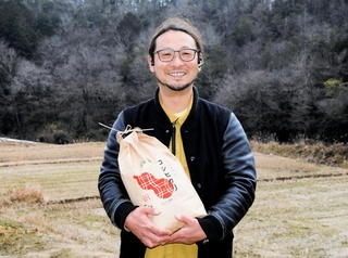 ＩＴを活用して栽培したコメを手にするひょうたん農場の須原隆一社長＝丹波市市島町中竹田