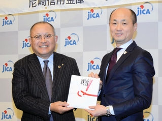 寄付の概要を説明する尼崎信用金庫の作田誠司理事長（左）とＪＩＣＡ関西の木村出所長＝神戸市中央区脇浜海岸通１