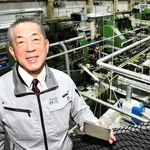 車載用リチウムイオン電池のケースを手にする冨士発條の藤井啓社長＝朝来市和田山町筒江