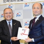 寄付の概要を説明する尼崎信用金庫の作田誠司理事長（左）とＪＩＣＡ関西の木村出所長＝神戸市中央区脇浜海岸通１