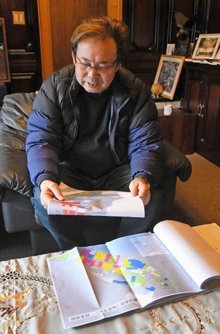 １０年後の耕作者の状況別に農地が色分けされた地元の地図を眺める山下和久さん＝兵庫県神河町鍛治