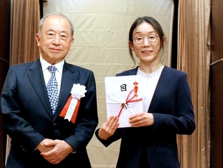 財団から目録を受け取った広島大の古水千尋助教（右）＝東京都千代田区