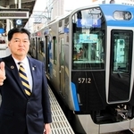 新型の５７００系車両を背に、出発信号のポーズを取る阪神電気鉄道の久須勇介社長＝大阪市福島区、阪神野田駅