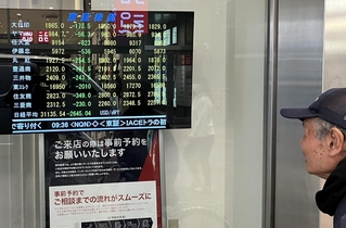 株の値動きを示す証券会社の株価ボード。大幅な下落に通行人が次々と足を止めた＝７日午前、神戸市中央区三宮町１