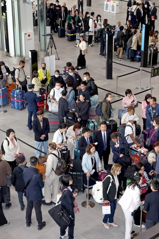 スターラックス航空や大韓航空の便に乗るために並ぶ乗客たち＝１８日午前、神戸市中央区、神戸空港第２ターミナル（撮影・笠原次郎）
