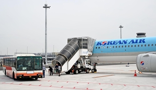 神戸空港に到着した大韓航空機から降り、第２ターミナルへ向かう旅客ら＝１８日午前、神戸市中央区（撮影・風斗雅博）