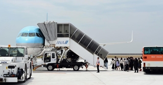大韓航空機に搭乗する乗客ら＝１８日午前、神戸市中央区、神戸空港（撮影・風斗雅博）