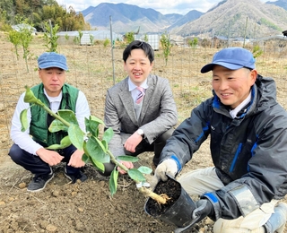日本丸天醤油の延賀海輝社長（中央）とスダチの苗木を手にする農業者ら＝たつの市新宮町香山