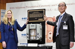 マイルストーン賞の贈呈式で、初代の魚群探知機とともに記念撮影に臨んだ古野電気の古野幸男社長（右）とＩＥＥＥのキャサリン・クレイマー会長＝西宮市芦原町