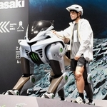 ４本脚で険しい道も走れる未来のモビリティ「コルレオ」の模型とトレイルランナーの上田瑠偉さん＝３日午前、大阪市此花区、夢洲