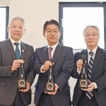 大阪・関西万博に合わせ発売する日本酒を披露したホテル・旅館の社長や日本盛の関係者ら＝西宮市用海町、日本盛