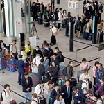 スターラックス航空や大韓航空の便に乗るために並ぶ乗客たち＝１８日午前、神戸市中央区、神戸空港第２ターミナル（撮影・笠原次郎）
