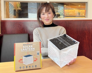 太陽光で発電するランタン「メガパフ」を手にするミープラスの三木美智代さん＝西宮市