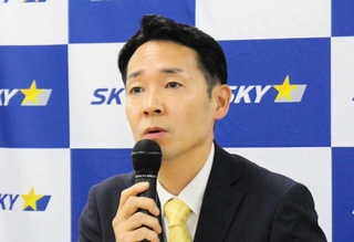 国際線の運航について説明するスカイマークの本橋学社長＝東京都大田区