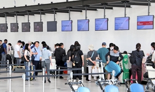 チェックインをする国際チャーター便旅客でにぎわう神戸空港第２ターミナルビルのロビー＝２０日午後、神戸市中央区