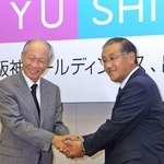 経営統合の記者会見後、握手する角和夫・阪急ホールディングス社長（左）と坂井信也・阪神電気鉄道社長＝２００６年９月、大阪市北区