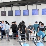 チェックインをする国際チャーター便旅客でにぎわう神戸空港第２ターミナルビルのロビー＝２０日午後、神戸市中央区