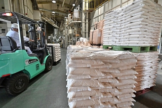 精米が完了し、出荷に向けて積み上げられる備蓄米入りの袋＝３日午前、加古川市内の精米会社（撮影・斎藤雅志）