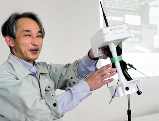 ひかり姫の栽培に役立つ機器を手に、土壌の水分を保つ大切さを強調する杉本琢真さん＝加西市別府町