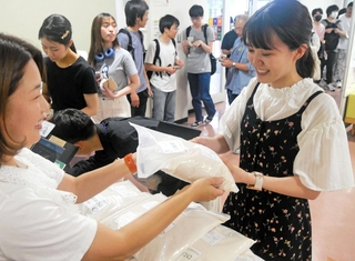学生向けの販売会でコメを買う学生＝神戸市灘区六甲台町、神戸大六甲台キャンパス