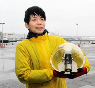 海に浮かべる球体型の発電設備の模型を手に、波力発電について語るイエローダックの中山繁生さん＝大阪市住之江区南港北２