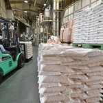 精米が完了し、出荷に向けて積み上げられる備蓄米入りの袋＝３日午前、加古川市内の精米会社（撮影・斎藤雅志）