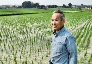 自身の田んぼの前で、コメ政策について語る深田秀一さん＝加西市下宮木町