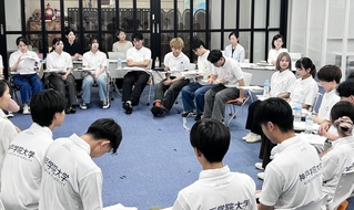 中間発表の内容について議論を交わす神戸松蔭大と神戸学院大の学生たち＝神戸市中央区脇浜町１、兵庫国際交流会館