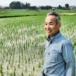 自身の田んぼの前で、コメ政策について語る深田秀一さん＝加西市下宮木町