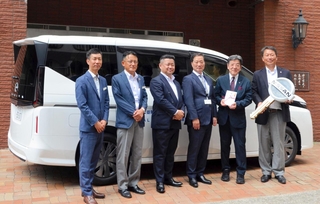 寄贈した福祉車両を背にしたＡＬＳＯＫや社会福祉法人光朔会の関係者ら＝神戸市中央区生田町１（同社提供）