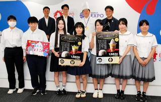 大阪・関西万博で販売するオリジナルスイーツを共同開発した神戸野田高校と石川県立輪島高校の生徒とまねき食品などの関係者＝大阪市此花区の夢洲