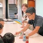 子どもたちにコーヒーの栽培や水素の魅力などについて説明するＵＣＣジャパンと川崎重工業の担当者ら＝神戸市中央区港島中町７、ＵＣＣグループ本社