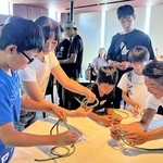 「学童ホテル」の体験会で地元の漁師（右端）からロープの結び方を習う小学生ら＝神戸市垂水区海岸通、ホテルセトレ神戸・舞子