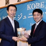 ＫＯＢＥジュニアハイスクールクラブの岩田哲也理事長（右）から、オフィシャルパートナーの楯を受け取るホームドライの太白守治社長＝神戸市中央区