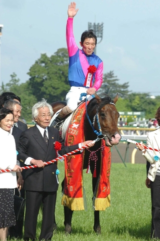 ２００６年の日本ダービーを制した石橋守騎手騎乗のメイショウサムソンと馬主の松本好雄さん（手前左から２人目）＝東京競馬場