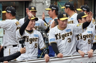 優勝パレードでファンに手を振る近本光司選手、大山悠輔選手ら阪神ナイン＝2023年11月、神戸市中央区