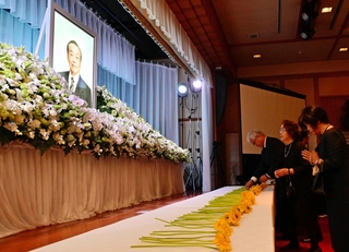 木下紘一氏の遺影を前に献花し、手を合わせる参列者ら＝洲本市小路谷、ホテルニューアワジ