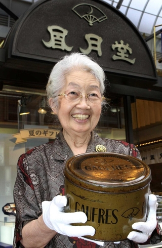 神戸空襲で唯一残ったゴーフルの缶を持つ下村俊子さん＝２０１１年、神戸市中央区元町通３、神戸凮月堂