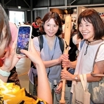 阪神タイガースの大山悠輔選手が実際に使ったバットを持ち、記念写真に納まる来場者＝大阪市此花区の夢洲