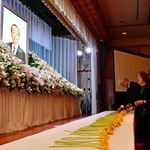木下紘一氏の遺影を前に献花し、手を合わせる参列者ら＝洲本市小路谷、ホテルニューアワジ
