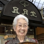 神戸空襲で唯一残ったゴーフルの缶を持つ下村俊子さん＝２０１１年、神戸市中央区元町通３、神戸凮月堂