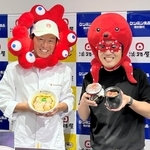 グルテンフリー仕様のひっぱりだこ飯を持つ淡路屋の柳本雄基副社長（右）とケンミン食品の高村祐輝社長＝神戸市中央区海岸通５、ケンミン食品本社