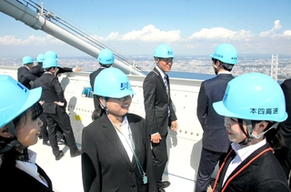 主塔上部で見学する本州四国連絡高速道路の内定者たち＝１日午後、明石海峡大橋