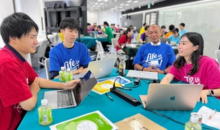 生成ＡＩによる業務課題の解決策を、企業の担当者（右から２人目）と議論する大学生ら＝神戸市中央区浜辺通５（神戸市提供）