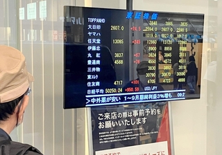 日経平均株価が一時５万円を超えた株価ボートを見つめる男性＝２７日午前、神戸市中央区三宮町１