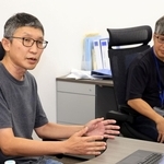 北川進氏の受賞を喜ぶアトミスの片岡大ＣＯＯ（左）と浅利大介ＣＥＯ＝８日午後、神戸市中央区港島南町７（撮影・丸山桃奈）