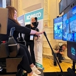 ウクライナ・キーウの会場に置かれた操縦席で神戸の重機を遠隔操作する女性（国土交通省提供）